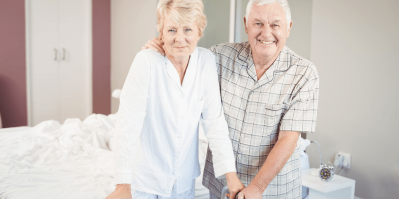 Elder couple and man arm around woman