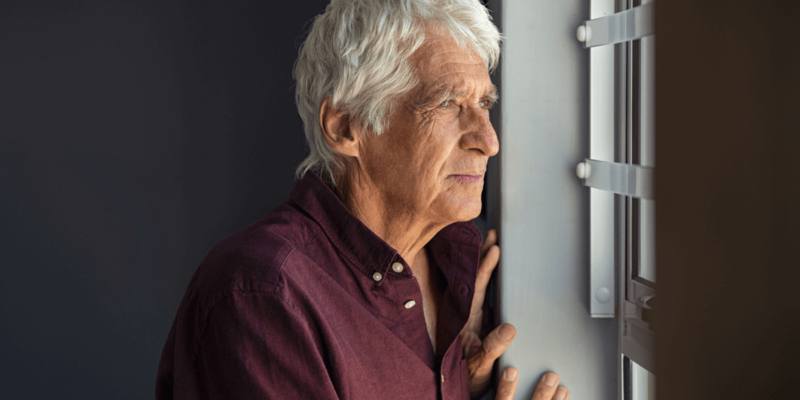 Senior man gazing out of the window.