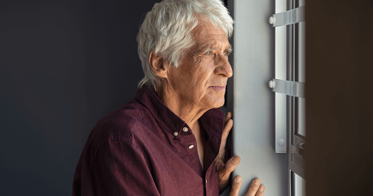 Senior man gazing out of the window.