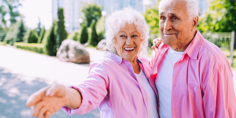 A happy senior couple in matching pink button ups for Clearwater's annual festivals.