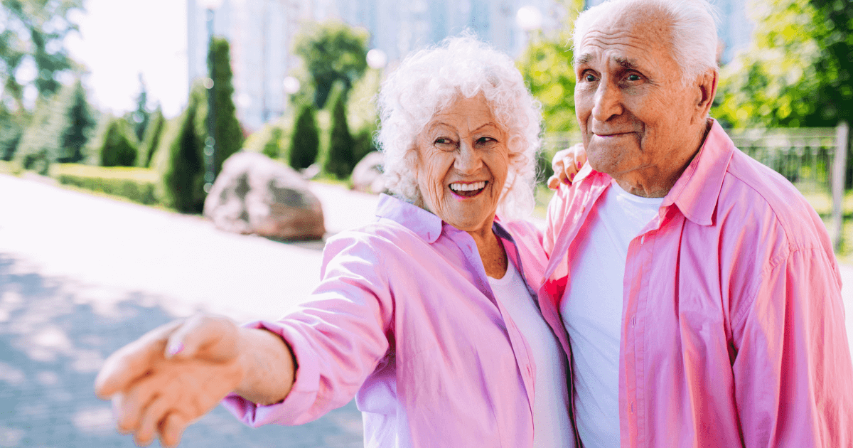 A happy senior couple in matching pink button ups for Clearwater's annual festivals.